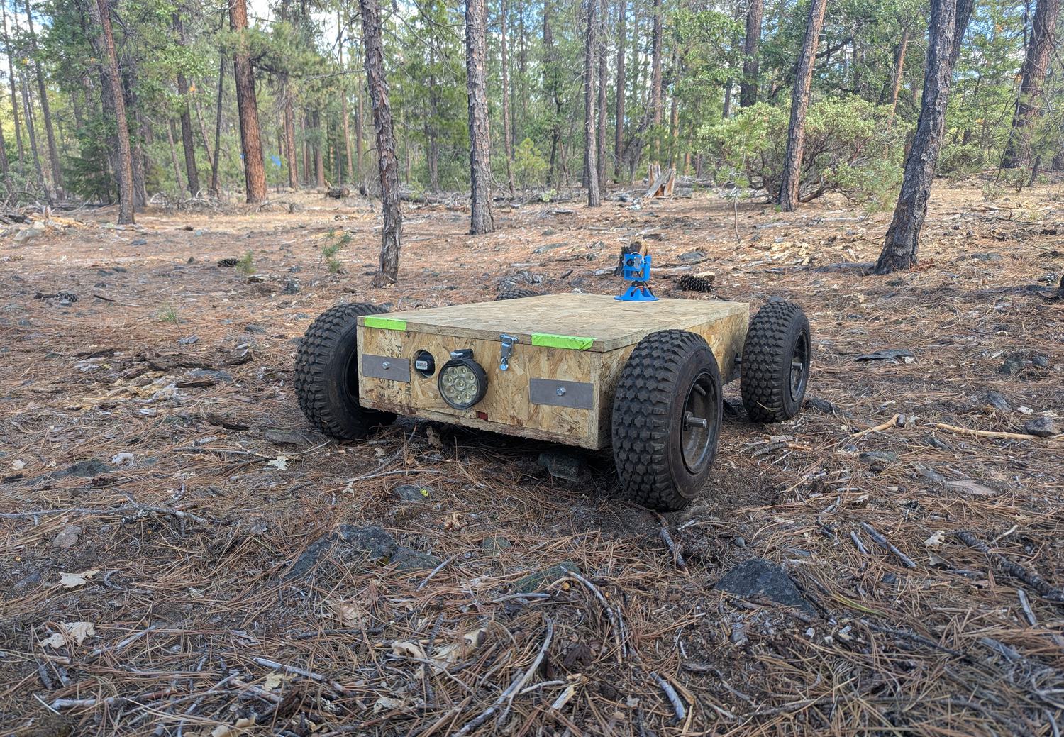 The proof-of-concept machine on the worksite, a compact four-wheeled vehicle on a patch of forest floor