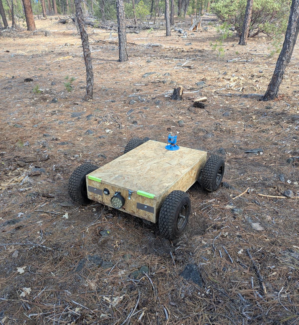 The machine parked among pine trees on the outdoor site